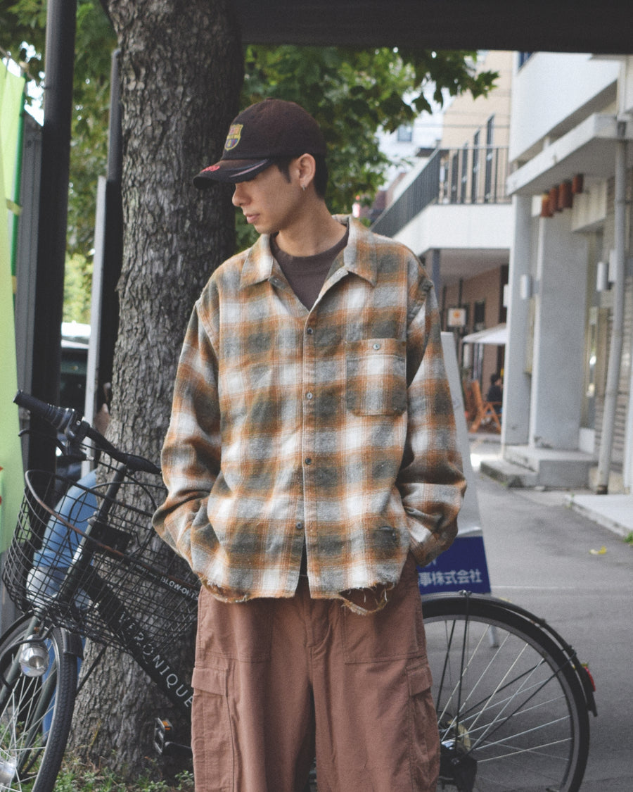 ANACHRONORMで以前リリースしていたリサイズシャツのシルエットをリファインした、ワイドシルエットシャツです。
随所に施された細かなステッチワークやダメージ加工にもご注目ください。
生地はリサイクルコットンとポリエステルを混紡したT/Cネップチェックで、起毛によるネップの風合いとメランジ染めの独特なムラ感が特徴です。
サスティナブルブリーチ加工とダメージ加工を施しており、環境に配慮しつつYELLOW×GREENカラーで仕上げています。