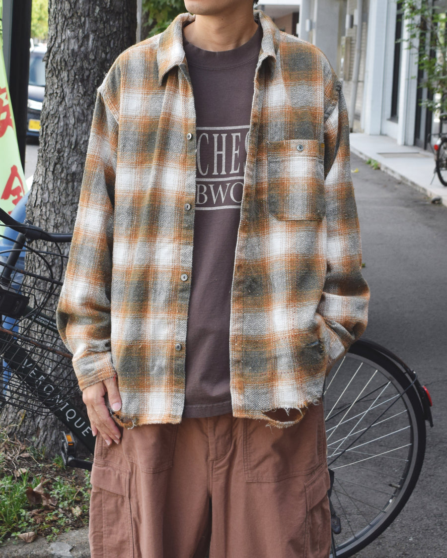 ANACHRONORMで以前リリースしていたリサイズシャツのシルエットをリファインした、ワイドシルエットシャツです。
随所に施された細かなステッチワークやダメージ加工にもご注目ください。
生地はリサイクルコットンとポリエステルを混紡したT/Cネップチェックで、起毛によるネップの風合いとメランジ染めの独特なムラ感が特徴です。
サスティナブルブリーチ加工とダメージ加工を施しており、環境に配慮しつつYELLOW×GREENカラーで仕上げています。