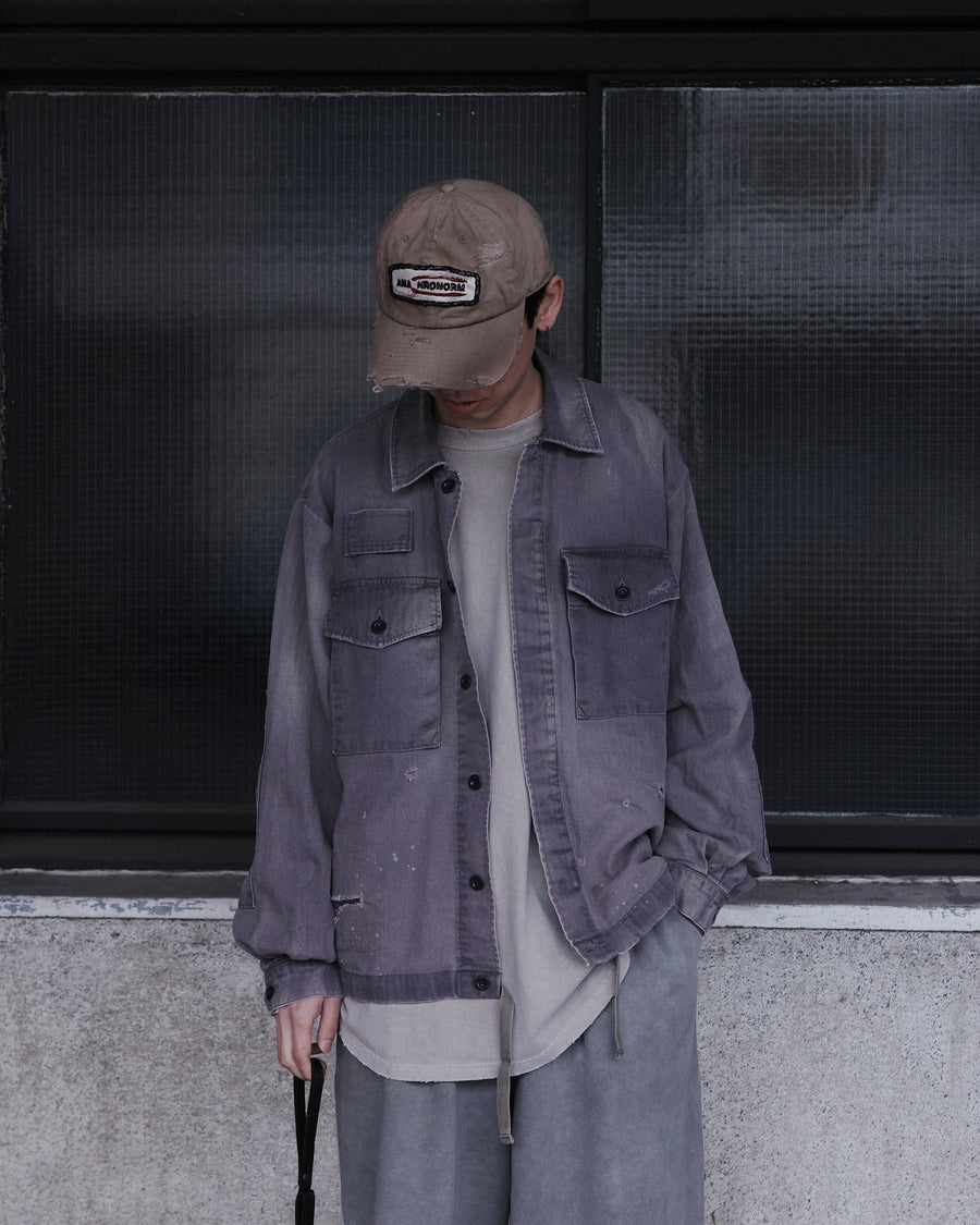 ミリタリーのシャツジャケットを現代的シルエットに更新。裾のドローコードでスタイルに合わせた変化を楽しめます。素材には肌馴染みの良い10sヘリンボンを採用。環境に配慮した特殊エイジング・サンフェード加工とダメージ加工を施すことで、クラシカルな生地にリアリティのある褪色感とヴィンテージライクな佇まいを表現しました。

A modern military shirt jacket with hem drawcords for an adjustable silhouette. Crafted from soft 10s herringbone, this CHARCOAL piece undergoes a special sun-fade and damage process. It achieves a realistic, time-worn vintage look with authentic distressing while minimizing environmental impact through eco-conscious processing.