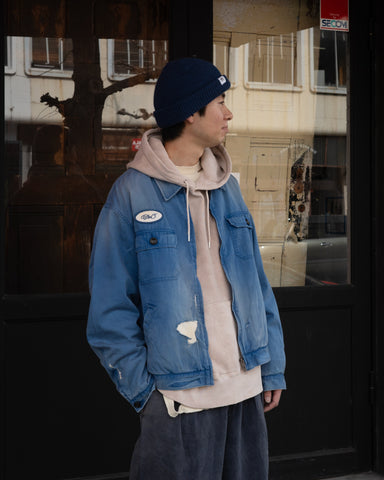 ヴィンテージのワークジャケットを現代的シルエットで再現。柔らかくコシのある20番手ツイルに、環境負荷を抑えた特殊エイジング・サンフェード加工、さらにダメージ加工を施すことで、長年着込んだようなリアルな色落ちと風合いを忠実に表現しました。裏地には高密度なコットンスレーキを採用。鮮やかなブルーのボディに、オリジナルワッペンがアクセントを添える、ヴィンテージ感溢れる一着です。
A modern reimagining of the classic vintage work jacket. Made from soft 20s twill and treated with a special sun-fade and damage process for a realistic, time-worn look. This BLUE jacket features high-density lining and original custom patches, creating a unique, heritage-inspired finish with authentic distressing.