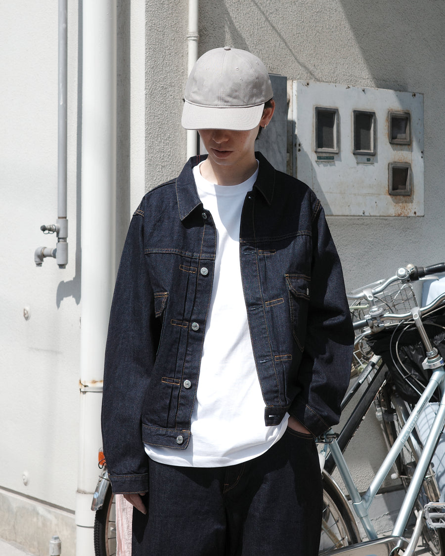 507XX（2ndタイプ）をベースに、現代的なシルエットへとリファインしたデニムジャケット。素材には7×10のナチュラルムラ糸を使用した11.5ozデニムを採用しました。最大の特徴は、絶妙な厚みと調和する自然なムラ感。ワンウォッシュで仕上げることで、オーセンティックなヴィンテージの雰囲気を漂わせつつ、洗練された佇まいを表現した一着です。A refined denim jacket based on the iconic 507XX (2nd type) with a modern silhouette. Crafted from 11.5oz denim using 7x10 natural slub yarns, it offers a perfect balance of weight and texture. This INDIGO piece features a one-wash finish, highlighting the fabric's authentic vintage character and subtle irregularities for a sophisticated yet