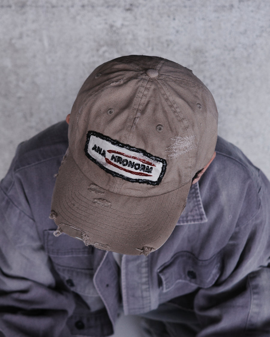 ダメージ加工とステッチ補強で、長年使い込まれた風合いを表現したキャップ。オリジナルワッペンにも同様の加工を施し、全体の統一感を高めました。素材には先染めのピグメントコットンキャンバスを採用。実用性とヴィンテージな佇まいを兼ね備え、スタイリングにこなれたアクセントを添える一着に仕上げています。

A distressed cap featuring reinforced stitching for a rugged, time-worn look. Both the body and the original patch are meticulously aged for a cohesive vintage aesthetic. Crafted from pre-dyed pigment cotton canvas, this BEIGE piece combines durability with a sophisticated, lived-in feel, perfect for adding character to any outfit.