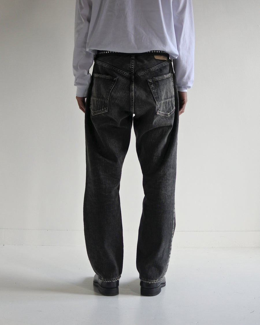 ANACHRONORM定番のレギュラーテーパード5Pパンツをベースに、リメイクで再構築した一本。
腰回りにはゆとりを持たせつつ、裾へ向かってすっきりと収まる美しいテーパードシルエットが特徴です。
タテ糸は硫化ロープ染色を施した芯白仕様で、ブラックからグレーへ自然にフェードする豊かな経年変化が魅力。
ムラ糸が生み出す自然な陰影により、ヴィンテージライクな表情を楽しめます。
さらにタテヨコに硫化ブラックのスラブ糸を使用し、ベーストーンを抑えながらもアタリを際立たせた奥行きのあるコントラストを表現。
リアルなユーズド感を備えた、加工映えする一本に仕上げています。
A reconstructed take on ANACHRONORM’s classic Regular Tapered 5P Pants, refined through its remake design.
The fit offers room around the waist with a clean taper toward the hem, ensuring both comfort and sharp lines.
Warp yarns a