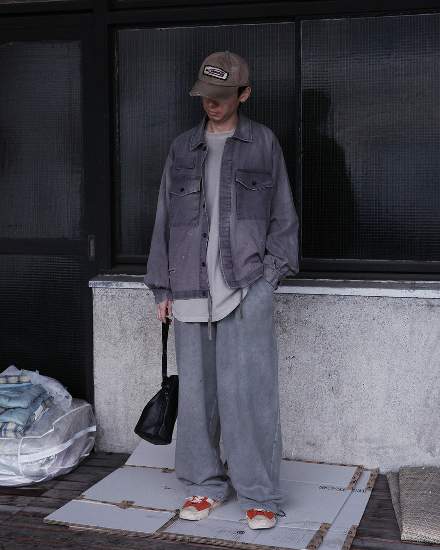 ミリタリーのシャツジャケットを現代的シルエットに更新。裾のドローコードでスタイルに合わせた変化を楽しめます。素材には肌馴染みの良い10sヘリンボンを採用。環境に配慮した特殊エイジング・サンフェード加工とダメージ加工を施すことで、クラシカルな生地にリアリティのある褪色感とヴィンテージライクな佇まいを表現しました。

A modern military shirt jacket with hem drawcords for an adjustable silhouette. Crafted from soft 10s herringbone, this CHARCOAL piece undergoes a special sun-fade and damage process. It achieves a realistic, time-worn vintage look with authentic distressing while minimizing environmental impact through eco-conscious processing.