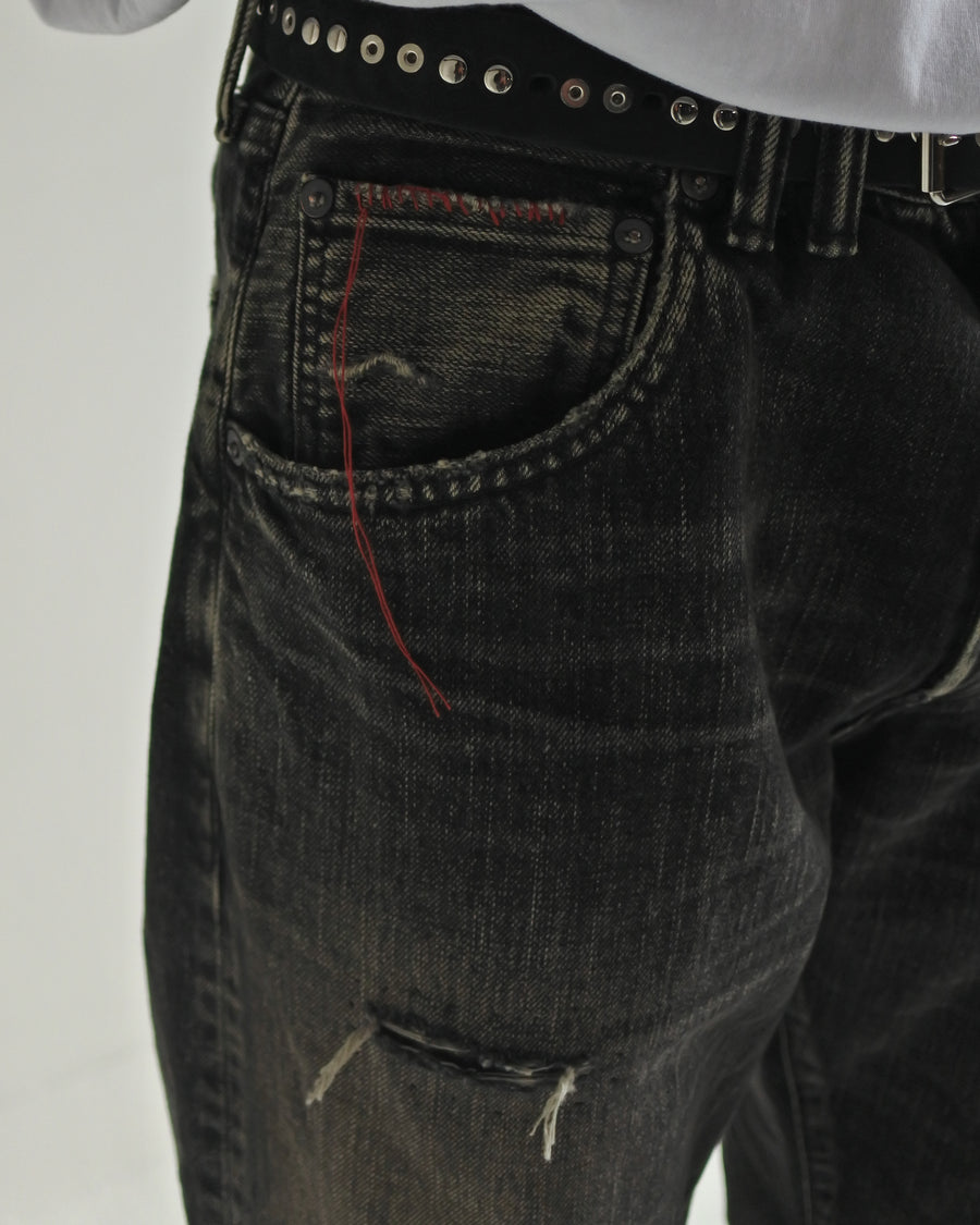 ANACHRONORM定番のレギュラーテーパード5Pパンツをベースに、リメイクで再構築した一本。
腰回りにはゆとりを持たせつつ、裾へ向かってすっきりと収まる美しいテーパードシルエットが特徴です。
タテ糸は硫化ロープ染色を施した芯白仕様で、ブラックからグレーへ自然にフェードする豊かな経年変化が魅力。
ムラ糸が生み出す自然な陰影により、ヴィンテージライクな表情を楽しめます。
さらにタテヨコに硫化ブラックのスラブ糸を使用し、ベーストーンを抑えながらもアタリを際立たせた奥行きのあるコントラストを表現。
リアルなユーズド感を備えた、加工映えする一本に仕上げています。
A reconstructed take on ANACHRONORM’s classic Regular Tapered 5P Pants, refined through its remake design.
The fit offers room around the waist with a clean taper toward the hem, ensuring both comfort and sharp lines.
Warp yarns a