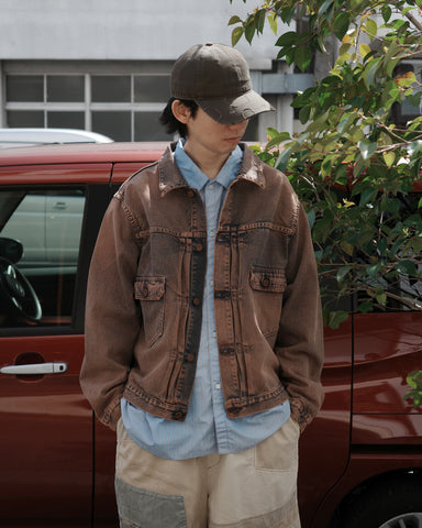 507XX 2ndタイプをベースにシルエットをリファインしたデニムジャケット。
12ozのオープンエンドデニムを使用し、ドライで硬さのある風合いと90年代ヴィンテージのようなシボ感が特徴です。
淡色のエイジング加工後に高濃度オーバーダイを施し、絶妙なムラ感を表現。
着用を重ねることで染料が馴染み、経年変化も楽しめます。A denim jacket based on the 507XX 2nd Type with a refined silhouette.
Made from 12oz open-end denim with a dry, firm texture and grain reminiscent of 90s vintage denim.
Finished with a high-concentration overdye after a light aging process to create subtle color variation.
The dye gradually settles with wear, allowing the fabric to develop character 