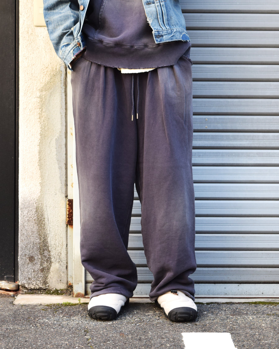 フロントにタックを施し、腰まわりにゆとりをもたせたスウェットパンツ。低速で丁寧に編み立てた30/10裏毛を使用し、ドライな質感と程よいハリ・コシを実現しました。硫化染め後、水を使用しないサスティナブルブリーチとダメージ加工を施すことで、環境に配慮しながら、長年の着用と日焼けによるヴィンテージの風合いをリアルに表現しています。
Sweatpants featuring front tucks for a relaxed waist silhouette. Crafted from 30/10 French Terry for a dry, structured touch, this PURPLE pair undergoes a waterless sustainable bleach and damage process. It authentically recreates the sun-faded look of a vintage favorite while minimizing environmental impact.