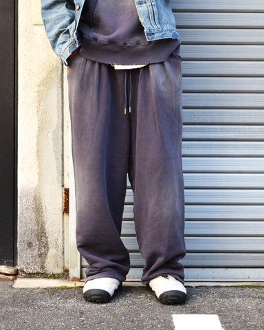 フロントにタックを施し、腰まわりにゆとりをもたせたスウェットパンツ。低速で丁寧に編み立てた30/10裏毛を使用し、ドライな質感と程よいハリ・コシを実現しました。硫化染め後、水を使用しないサスティナブルブリーチとダメージ加工を施すことで、環境に配慮しながら、長年の着用と日焼けによるヴィンテージの風合いをリアルに表現しています。
Sweatpants featuring front tucks for a relaxed waist silhouette. Crafted from 30/10 French Terry for a dry, structured touch, this PURPLE pair undergoes a waterless sustainable bleach and damage process. It authentically recreates the sun-faded look of a vintage favorite while minimizing environmental impact.