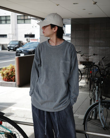 こだわりのオリジナルカラーで仕上げたロングスリーブTシャツ。幾度もの染色テストを重ね、他にはない絶妙な色味を追求しました。素材にはローゲージで編み立てたコットン天竺を採用し、程よい厚みとクリアな質感を両立。特殊顔料染めを施すことで、グレーの柔らかな発色の中に奥行きのある表情と、独特なこなれ感を引き出しています。

A long-sleeve T-shirt featuring a meticulously developed original color. Crafted from a relatively low-gauge cotton jersey for a clean yet structured look. This GRAY piece is treated with a special pigment dye, achieving a unique depth of color and a sophisticated, lived-in texture that results from extensive color testing.