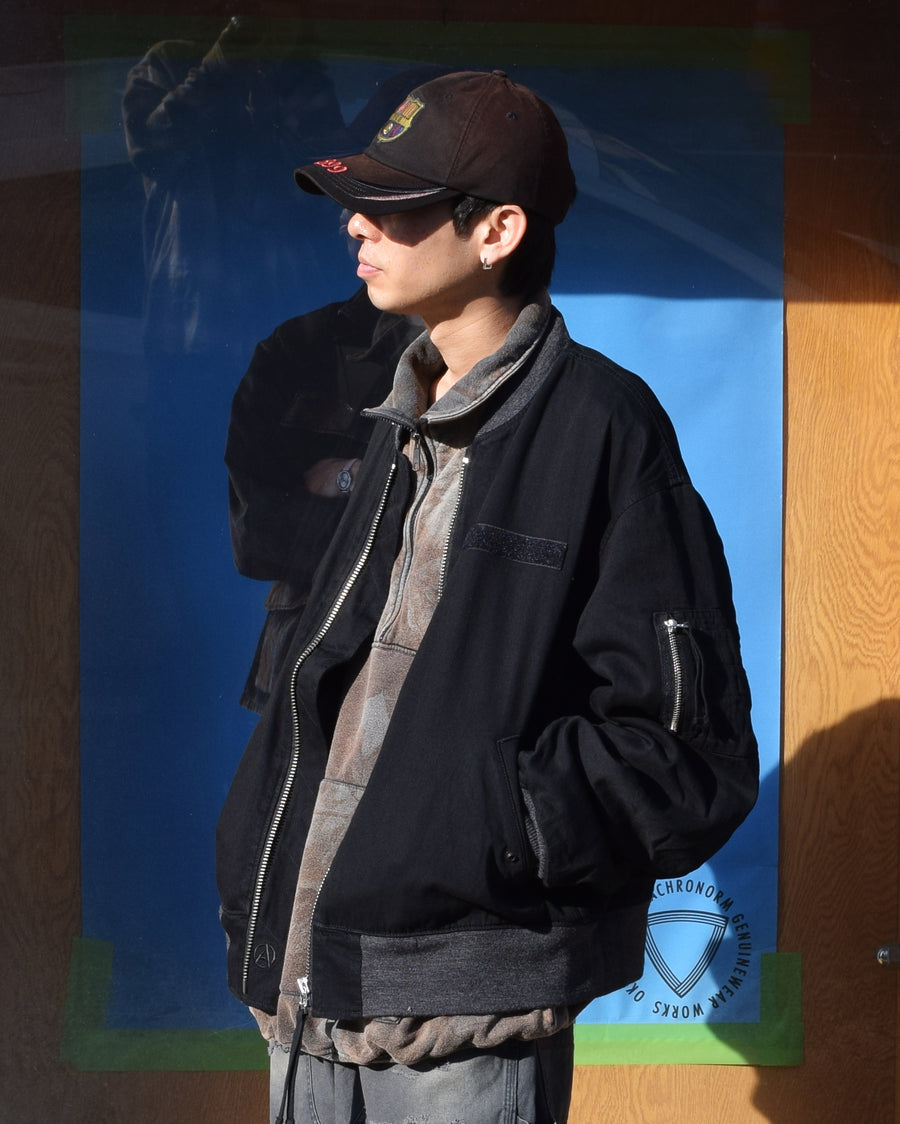 【 商品名：デュアルデニムMA-1 】

本製品は、ブランドのメイン素材であるデニムを使用し、ディティールを忠実に再現しながらシルエットを整えたブラックカラーのMA-1ジャケットです。中綿は入っていませんが、ライトオンスのデニムを採用し、二重縫製によって柔らかさと程よい肉感を両立した着心地の良い一着に仕上げています。生地にはムラ糸を使用した8ozデニムを採用しており、シャープなムラ形状と粗野な風合いが、より一層ヴィンテージ感を引き立てます。また、加工にはワンウォッシュを施し、自然な風合いを持たせています。