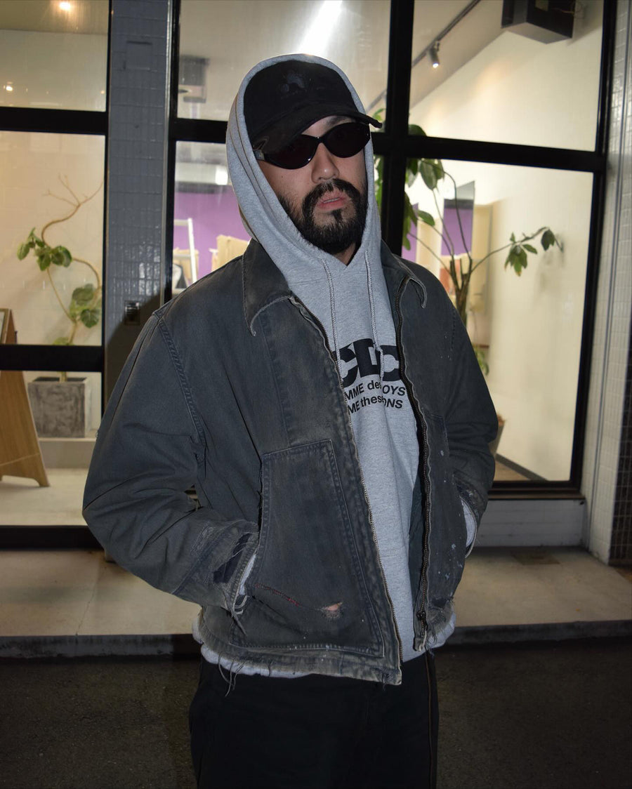 【 商品名：リメイクデトロイトダックジャケット 】

本製品は、ゆとりのある身幅とややクロップド丈に設計されたブラックカラーのジャケットで、インナーアイテムとのレイヤードを楽しめるバランスの良いシルエットが特徴です。生地には頒布の中でも最も薄手の11号帆布生地を採用しており、強度・耐久性に優れ、着用を重ねるごとにアタリなどの経年変化を味わえる素材です。さらに、水や薬品の使用量を抑えながら生地の凹凸部分のアタリを強調し、同時に自然な脱色感を生み出す特殊エイジング加工を施し、加えてサンフェードによるダメージ加工を加えることで、より奥行きのある表情に仕上げています。