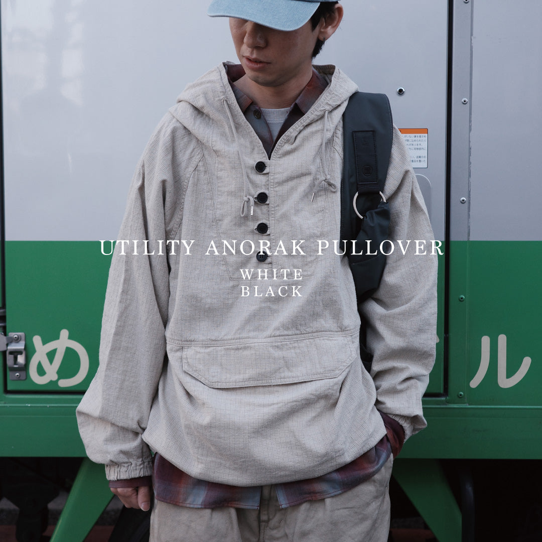 フード口のボタンの開閉により、首周りのニュアンスを自在に調整できる一着。素材には、麻カスや節を活かしたネップ糸を織り交ぜたコットンリネンチェックを採用しました。ドライタッチな生地にワンウォッシュを施すことで、麻特有のハリ感を残しつつ、肌馴染みの良い柔らかな風合いと豊かな表情を引き出しています。This piece features adjustable hood buttons to alternate between a clean look and a relaxed neckline. Crafted from a cotton-linen check weave with rustic nep yarns, it highlights the natural texture of the fibers. The BLACK fabric is one-washed to balance a crisp, dry touch with a soft, broken-in feel, creating a sophisticated yet comfortable aesthetic.