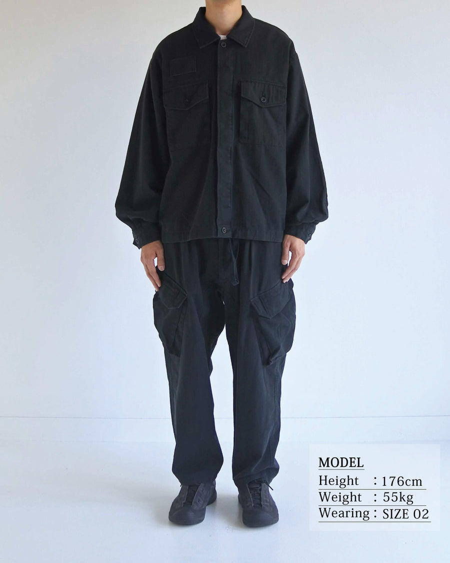 ミリタリーのシャツジャケットを現代的シルエットに更新。裾のドローコードで着丈のニュアンスを自在に調整可能です。素材には、やや甘織りで肌馴染みの良い10sヘリンボンを採用。ストーンバイオウォッシュを施すことで、クラシカルな生地感に柔らかな風合いとこなれ感をプラスした、着回し力の高い一着に仕上げました。

A modern update to the classic military shirt jacket, featuring hem drawcords for an adjustable silhouette. Crafted from 10s herringbone, slightly loose-knitted for a soft, comfortable touch. This BLACK piece has been treated with a stone bio-wash, giving the traditional weave a natural, worn-in texture and a sophisticated casual feel.