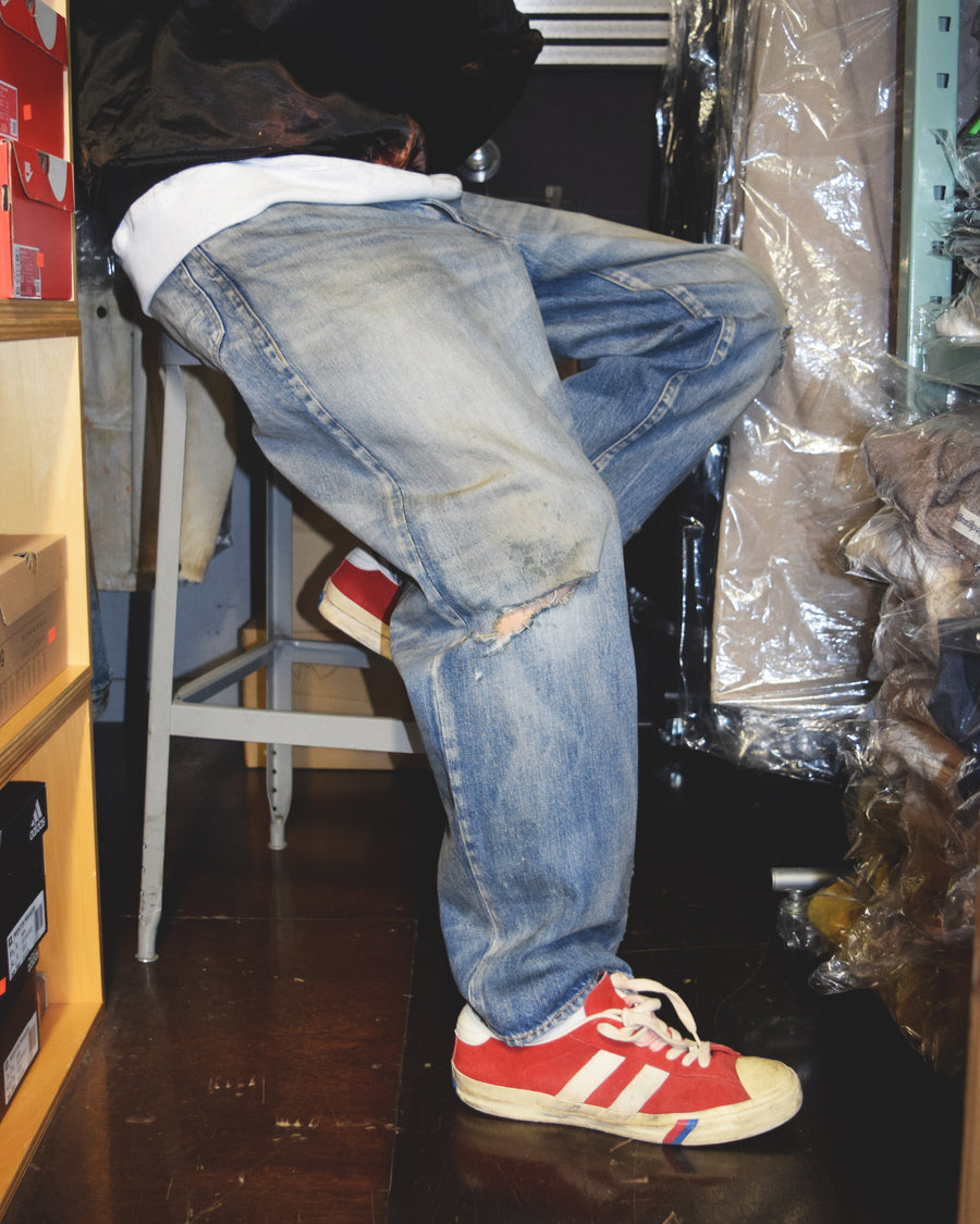 1985年のLEVIS 550をベースに再構築した、ワイドテーパードのリメイク5Pデニム。
12.5ozデニムのタテ糸には中白のインディゴロープ染色糸を使用し、ムラ感のある豊かな表情を演出。タテ落ちとインディゴの濃淡を活かすことで、ヴィンテージにはない独自の風合いを表現しています。さらに手作業のトーンコントロールと特別なエイジング加工を加えることで奥行きある仕上がりに。オリジナル染料の吹き付けにより、モダンでソリッドな印象も併せ持つ一本です。This remade 5P denim features a wide tapered silhouette inspired by the 1985 LEVIS 550.
The 12.5oz denim uses medium-white indigo rope–dyed warp yarns, giving it a textured, slubby character.
By highlighting vertical fading and vivid indigo variations, it achieves a look distinct from vin