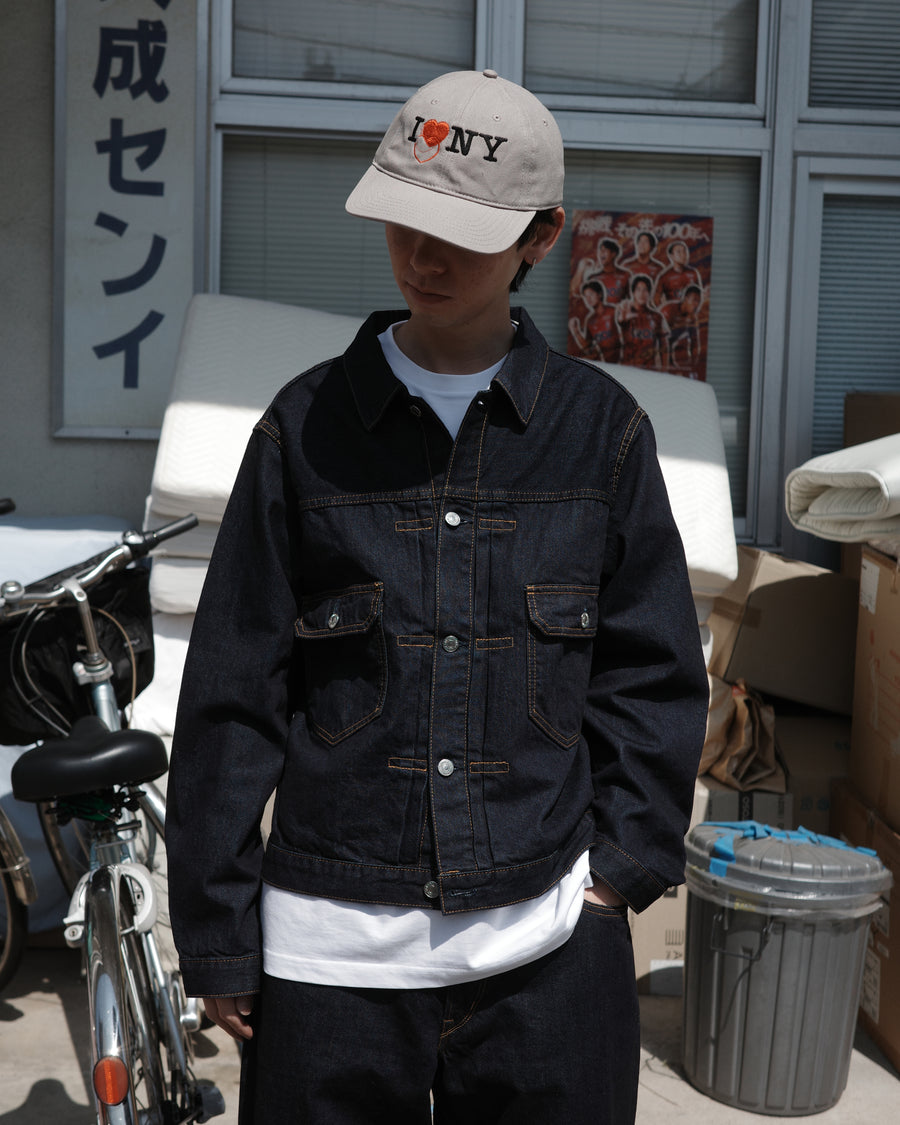 507XX（2ndタイプ）をベースに、現代的なシルエットへとリファインしたデニムジャケット。素材には7×10のナチュラルムラ糸を使用した11.5ozデニムを採用しました。最大の特徴は、絶妙な厚みと調和する自然なムラ感。ワンウォッシュで仕上げることで、オーセンティックなヴィンテージの雰囲気を漂わせつつ、洗練された佇まいを表現した一着です。A refined denim jacket based on the iconic 507XX (2nd type) with a modern silhouette. Crafted from 11.5oz denim using 7x10 natural slub yarns, it offers a perfect balance of weight and texture. This INDIGO piece features a one-wash finish, highlighting the fabric's authentic vintage character and subtle irregularities for a sophisticated yet