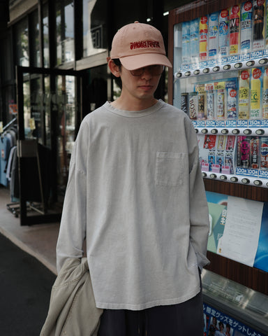 こだわりのオリジナルカラーで仕上げたロングスリーブTシャツ。幾度もの染色テストを重ね、他にはない絶妙な色味を追求しました。素材にはローゲージで編み立てたコットン天竺を採用し、程よい厚みとクリアな質感を両立。特殊顔料染めを施すことで、BEIGEの柔らかな発色の中に奥行きのある表情と、独特なこなれ感を引き出しています。

A long-sleeve T-shirt featuring a meticulously developed original color. Crafted from a relatively low-gauge cotton jersey for a clean yet structured look. This BEIGE piece is treated with a special pigment dye, achieving a unique depth of color and a sophisticated, lived-in texture that results from extensive color testing.