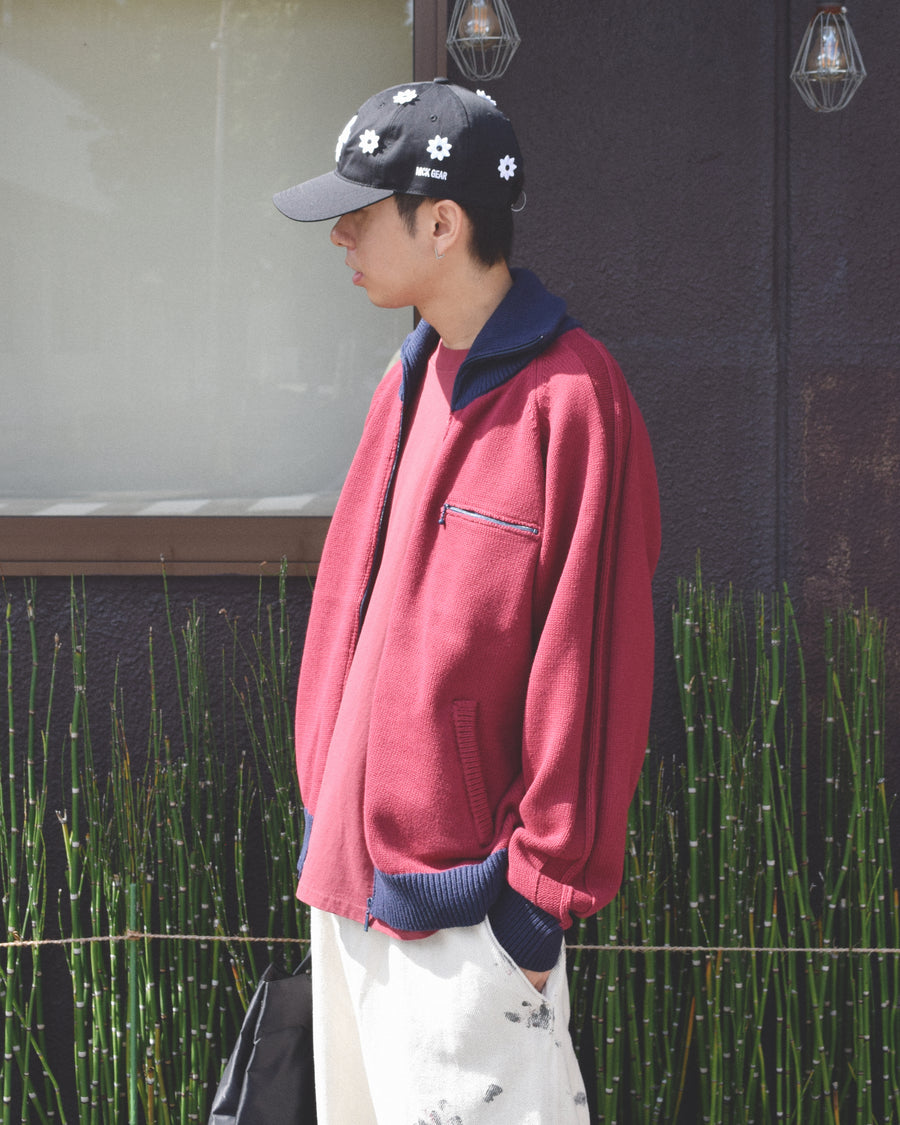 コットンニットを使用したドライバーズニット。
太番手の強撚糸による特殊な天竺編みで、適度なハリと風合いを持たせています。
ゆとりのある身幅ながら、アウターのインナーとしても使いやすいバランスの取れたシルエットに仕上げました。コットン素材のためホームクリーニングも可能です。
カラーは深みのあるバーガンディー。