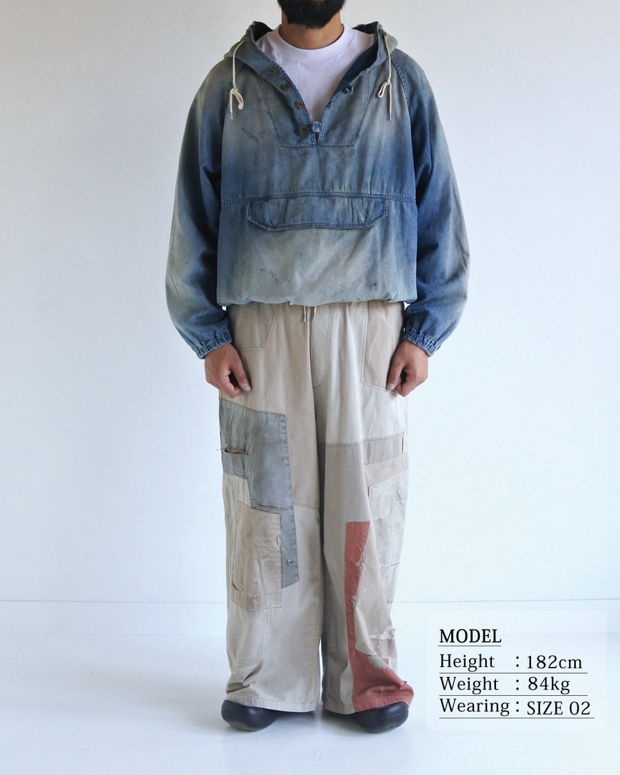 フード口のボタンの開閉により、首まわりのニュアンスを変えて楽しめる一着。素材には、経糸にコットンムラ糸、緯糸に綿麻混紡糸を使用した綿麻6ozデニムを採用しました。シャープなムラ感とリネン混ならではの粗野な風合いが、ヴィンテージの魅力を引き立てます。エイジング加工を施すことで、全体にリアリティのあるアタリ感を出し、長年着込んだような深みのある表情に仕上げました。A versatile piece featuring adjustable hood buttons to create a clean or relaxed neckline. Crafted from 6oz cotton-linen denim, the fabric combines sharp slub textures with a rustic linen feel for an authentic vintage character. Treated with an aging process to create realistic wear and fade, this INDIGO garment offers a sophisti