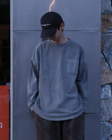 こだわりのオリジナルカラーで仕上げたロングスリーブTシャツ。幾度もの染色テストを重ね、他にはない絶妙な色味を追求しました。素材にはローゲージで編み立てたコットン天竺を採用し、程よい厚みとクリアな質感を両立。特殊顔料染めを施すことで、グレーの柔らかな発色の中に奥行きのある表情と、独特なこなれ感を引き出しています。

A long-sleeve T-shirt featuring a meticulously developed original color. Crafted from a relatively low-gauge cotton jersey for a clean yet structured look. This GRAY piece is treated with a special pigment dye, achieving a unique depth of color and a sophisticated, lived-in texture that results from extensive color testing.