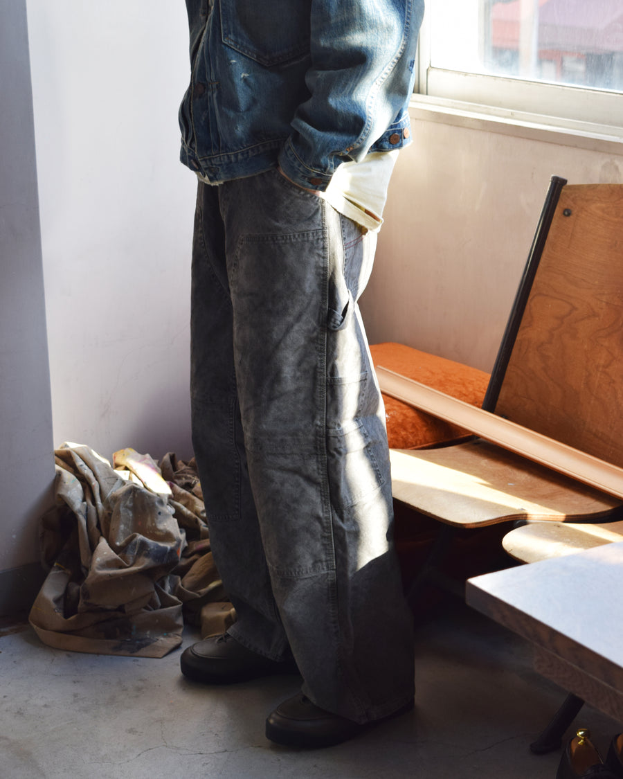 通年着用できるスタンダードなペインターパンツ。ややワイドで長めに設定したレングスは、ミリ単位の調整により絶妙なバランスに仕上げました。素材には強度と耐久性に優れた8号帆布を採用。特殊顔料染めを施すことで、ムラ感のある独自の奥行きと、穿き込むほどにアタリが増す豊かな経年変化を楽しめる一本です。

Standard painter pants designed for year-round wear. The slightly wide, long-length silhouette has been carefully refined for a perfect balance. Crafted from durable No.8 canvas, this BLACK pair features a special pigment dye that creates a unique, mottled depth. The rugged fabric is built to develop a beautiful patina and character over time.