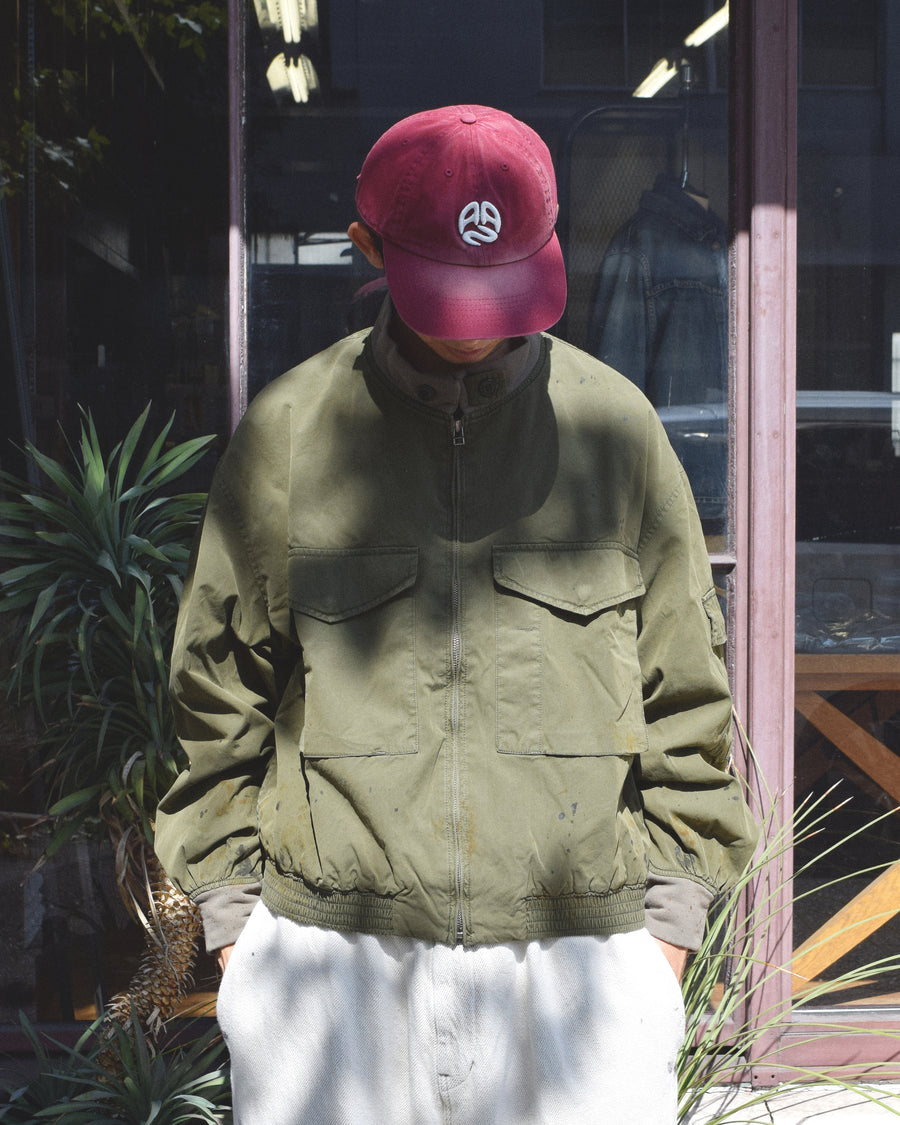 1950年代の希少なフライトジャケットをベースにシルエットを調整し、特徴的なディテールを再現したオリーブカラーのジャケット。
生地にはM1951 ARCTIC OVER PANTSを解析して再現したリプロ素材を使用し、光沢感のあるブライトナイロンを採用。
毛焼きをせずタンブラー仕上げでヴィンテージ感を演出しています。