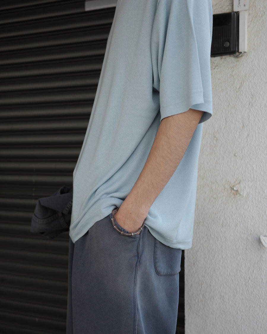 ディテールを極限まで削ぎ落とし、着心地とシルエットを追求したニットTシャツ。気候変化に対応する新たなアプローチとして、軽量で吸水・放湿性に優れた竹（バンブー）素材を採用しました。滑らかでとろみのある肌触りと、袖を通した瞬間に感じる清涼感は格別です。家庭洗濯も可能で、日常に圧倒的な心地よさを提供します。

A minimalist knit T-shirt focused entirely on fit and comfort. Crafted from bamboo yarn, this lightweight, durable material offers exceptional moisture absorption and a refreshing cool-to-the-touch feel. This SAX piece features a silky, fluid drape that provides overwhelming comfort, perfect for changing climates, and is conveniently home-washable.