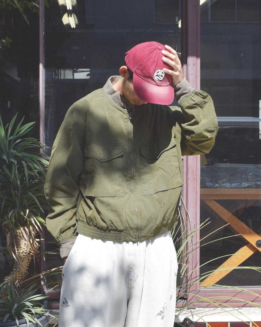 1950年代の希少なフライトジャケットをベースにシルエットを調整し、特徴的なディテールを再現したオリーブカラーのジャケット。
生地にはM1951 ARCTIC OVER PANTSを解析して再現したリプロ素材を使用し、光沢感のあるブライトナイロンを採用。
毛焼きをせずタンブラー仕上げでヴィンテージ感を演出しています。