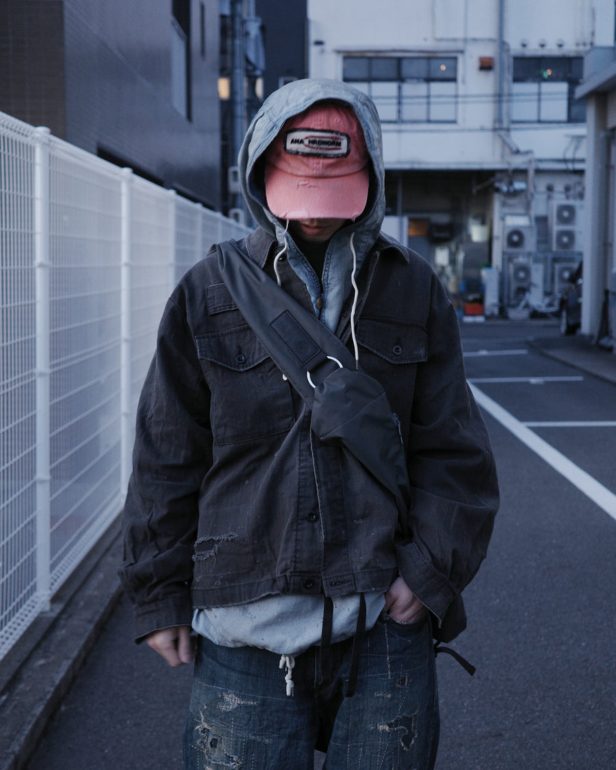 ミリタリーのシャツジャケットを現代的シルエットに更新。裾のドローコードでスタイルに合わせた変化を楽しめます。素材には肌馴染みの良い10sヘリンボンを採用。環境に配慮した特殊エイジング・サンフェード加工とダメージ加工を施すことで、クラシカルな生地にリアリティのある褪色感とヴィンテージライクな佇まいを表現しました。

A modern military shirt jacket with hem drawcords for an adjustable silhouette. Crafted from soft 10s herringbone, this BLACK piece undergoes a special sun-fade and damage process. It achieves a realistic, time-worn vintage look with authentic distressing while minimizing environmental impact through eco-conscious processing.