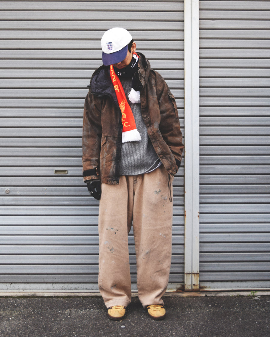 U.S. ARMYのフィールドジャケットをベースに再構築したパーカー。
中綿キルティングを採用し、重すぎず長いシーズン着用可能。
表地はパラフィンコーティングによる軽い撥水性を備えています。
20/リップストップ生地は裂けにくく、マットでしなやかな質感が特徴。
硫化染め後、水を一切使わないサステナブルブリーチを施した特別加工。
独特の風合いと環境配慮を両立した一着です。
A refined take on the U.S. Army field jacket silhouette.
Medium-weight quilted padding offers seasonal versatility without excess bulk.
The paraffin-coated shell provides light water repellency.
Crafted from durable 20/ripstop with a matte, supple texture.
Finished with sulfide dye and a fully water-free sustainable bleachi