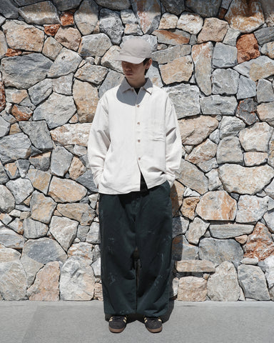 ミニマルなデザインのオープンカラーシャツ。レーヨンリネン特有の自然なドレープ感を活かし、リラックス感のあるゆとりを持たせたシルエットに仕上げました。麻のスラブ感が際立つざっくりとした表情ながら、清涼感のある薄手素材を採用。バイオワッシャー加工を施すことで、さらりとした肌触りとしなやかさを高めた、非常に心地よい一着です。

A minimalist open-collar shirt designed to highlight the natural drape of its fabric. Crafted from a rayon-linen bio-washer blend, this OFF WHITE piece features a breathable, textured look with a cool, lightweight feel. The bio-wash treatment enhances the rayon's suppleness and the linen's crispness, resulting in a soft, smooth texture that is exce