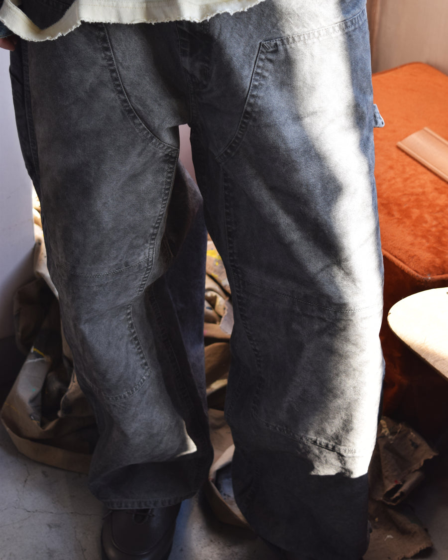 通年着用できるスタンダードなペインターパンツ。ややワイドで長めに設定したレングスは、ミリ単位の調整により絶妙なバランスに仕上げました。素材には強度と耐久性に優れた8号帆布を採用。特殊顔料染めを施すことで、ムラ感のある独自の奥行きと、穿き込むほどにアタリが増す豊かな経年変化を楽しめる一本です。

Standard painter pants designed for year-round wear. The slightly wide, long-length silhouette has been carefully refined for a perfect balance. Crafted from durable No.8 canvas, this BLACK pair features a special pigment dye that creates a unique, mottled depth. The rugged fabric is built to develop a beautiful patina and character over time.