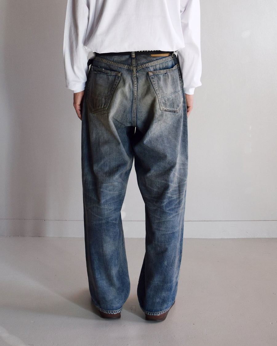 1985年のLEVIS 550をベースに再構築した、ワイドテーパードのリメイク5Pデニム。
12.5ozデニムのタテ糸には中白のインディゴロープ染色糸を使用し、ムラ感のある豊かな表情を演出。タテ落ちとインディゴの濃淡を活かすことで、ヴィンテージにはない独自の風合いを表現しています。さらに手作業のトーンコントロールと特別なエイジング加工を加えることで奥行きある仕上がりに。オリジナル染料の吹き付けにより、モダンでソリッドな印象も併せ持つ一本です。This remade 5P denim features a wide tapered silhouette inspired by the 1985 LEVIS 550.
The 12.5oz denim uses medium-white indigo rope–dyed warp yarns, giving it a textured, slubby character.
By highlighting vertical fading and vivid indigo variations, it achieves a look distinct from vin