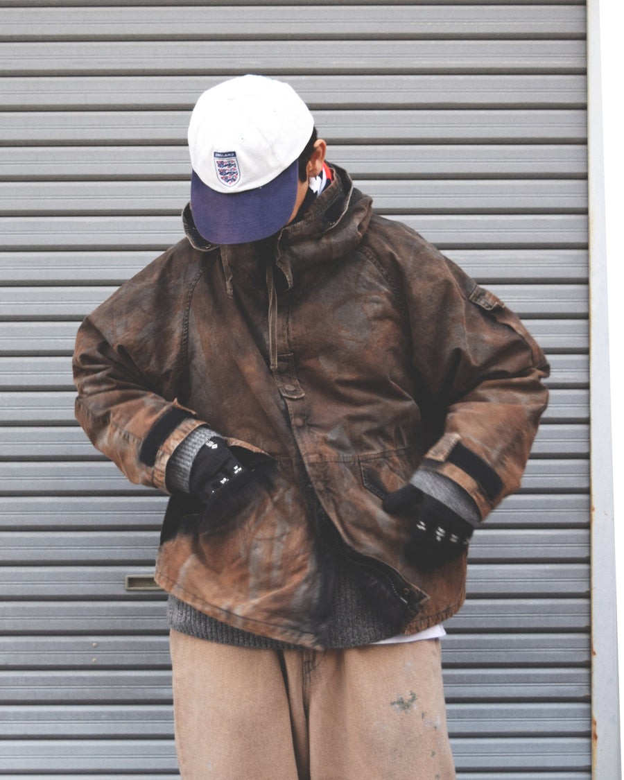 U.S. ARMYのフィールドジャケットをベースに再構築したパーカー。
中綿キルティングを採用し、重すぎず長いシーズン着用可能。
表地はパラフィンコーティングによる軽い撥水性を備えています。
20/リップストップ生地は裂けにくく、マットでしなやかな質感が特徴。
硫化染め後、水を一切使わないサステナブルブリーチを施した特別加工。
独特の風合いと環境配慮を両立した一着です。
A refined take on the U.S. Army field jacket silhouette.
Medium-weight quilted padding offers seasonal versatility without excess bulk.
The paraffin-coated shell provides light water repellency.
Crafted from durable 20/ripstop with a matte, supple texture.
Finished with sulfide dye and a fully water-free sustainable bleachi