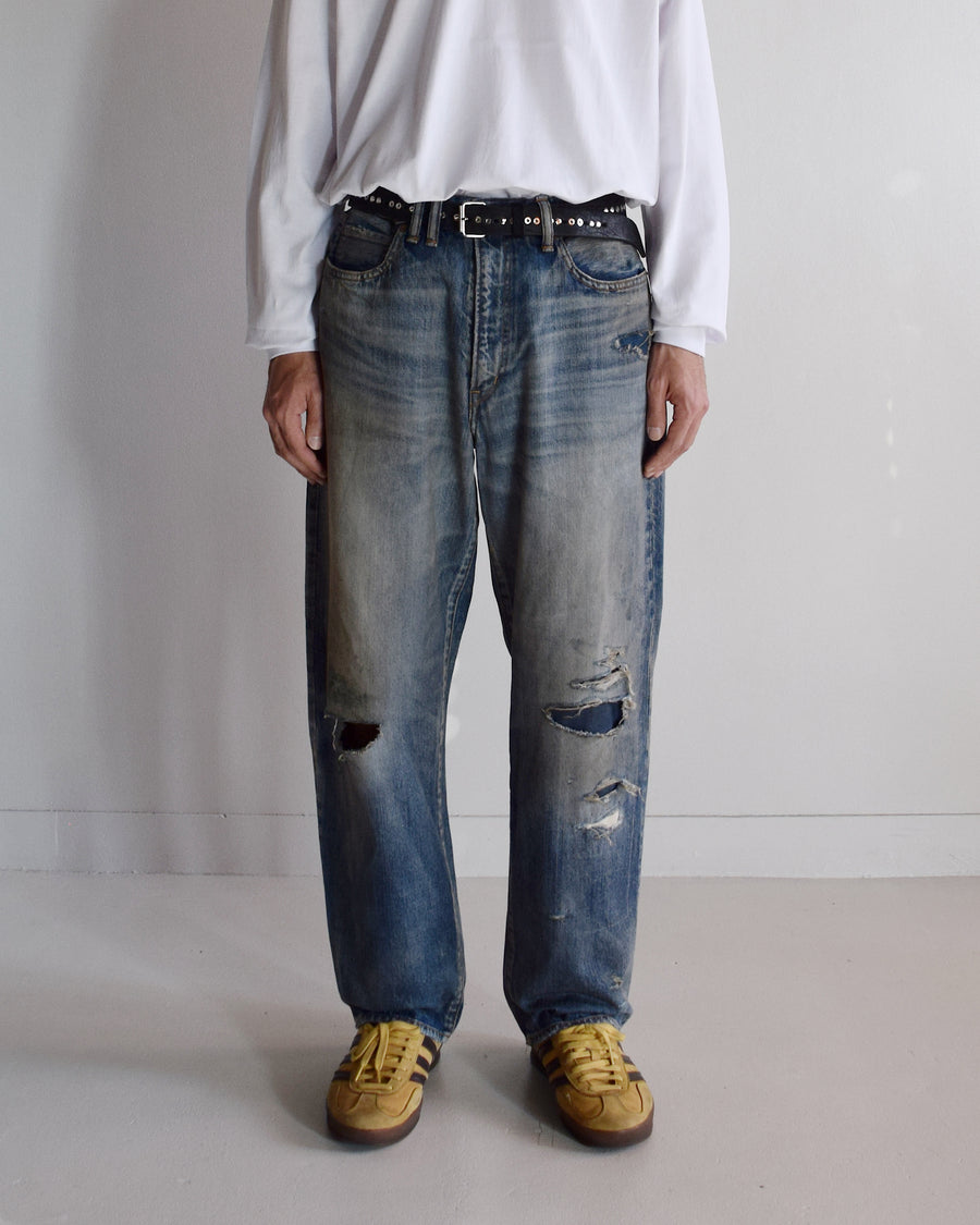 1985年のLEVIS 550をベースに再構築した、ワイドテーパードのリメイク5Pデニム。
12.5ozデニムのタテ糸には中白のインディゴロープ染色糸を使用し、ムラ感のある豊かな表情を演出。タテ落ちとインディゴの濃淡を活かすことで、ヴィンテージにはない独自の風合いを表現しています。さらに手作業のトーンコントロールと特別なエイジング加工を加えることで奥行きある仕上がりに。オリジナル染料の吹き付けにより、モダンでソリッドな印象も併せ持つ一本です。This remade 5P denim features a wide tapered silhouette inspired by the 1985 LEVIS 550.
The 12.5oz denim uses medium-white indigo rope–dyed warp yarns, giving it a textured, slubby character.
By highlighting vertical fading and vivid indigo variations, it achieves a look distinct from vin