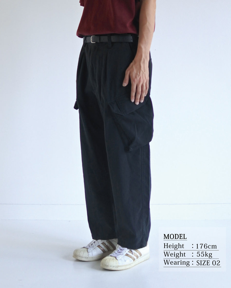 ミリタリートラウザーズをベースに、シルエットを現代的にリファイン。印象的な斜めのカーゴポケットが、立体感と実用性を両立させています。裾にかけて緩やかに絞られたテーパードラインにより、無骨ながらも洗練された印象に。素材には肌馴染みの良い10sヘリンボンを採用し、ストーンバイオウォッシュで柔らかな風合いとこなれ感を引き出しました。

Military trousers refined with a modern tapered silhouette. The distinctive slanted cargo pockets offer both practical utility and a structured look. Crafted from soft, classic 10s herringbone, this BLACK pair has been treated with a stone bio-wash, providing a comfortable, worn-in texture and a sophisticated take on rugged style.