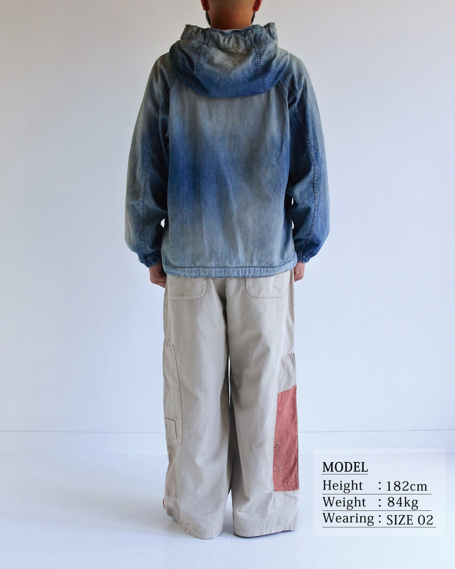 フード口のボタンの開閉により、首まわりのニュアンスを変えて楽しめる一着。素材には、経糸にコットンムラ糸、緯糸に綿麻混紡糸を使用した綿麻6ozデニムを採用しました。シャープなムラ感とリネン混ならではの粗野な風合いが、ヴィンテージの魅力を引き立てます。エイジング加工を施すことで、全体にリアリティのあるアタリ感を出し、長年着込んだような深みのある表情に仕上げました。A versatile piece featuring adjustable hood buttons to create a clean or relaxed neckline. Crafted from 6oz cotton-linen denim, the fabric combines sharp slub textures with a rustic linen feel for an authentic vintage character. Treated with an aging process to create realistic wear and fade, this INDIGO garment offers a sophisti