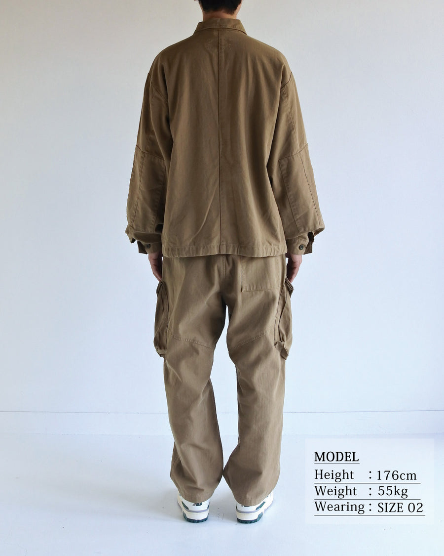 ミリタリーのシャツジャケットを現代的シルエットに更新。裾のドローコードで着丈のニュアンスを自在に調整可能です。素材には、やや甘織りで肌馴染みの良い10sヘリンボンを採用。ストーンバイオウォッシュを施すことで、クラシカルな生地感に柔らかな風合いとこなれ感をプラスした、着回し力の高い一着に仕上げました。

A modern update to the classic military shirt jacket, featuring hem drawcords for an adjustable silhouette. Crafted from 10s herringbone, slightly loose-knitted for a soft, comfortable touch. This KHAKI piece has been treated with a stone bio-wash, giving the traditional weave a natural, worn-in texture and a sophisticated casual feel.