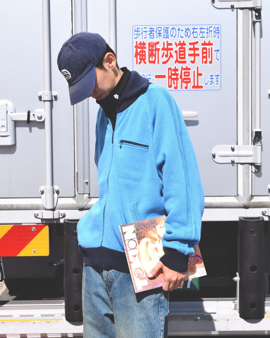 コットンニットを使用したドライバーズニット。
太番手の強撚糸による特殊な天竺編みで、適度なハリと風合いを持たせています。
ゆとりのある身幅ながら、アウターのインナーとしても使いやすいバランスの取れたシルエットに仕上げました。コットン素材のためホームクリーニングも可能です。
カラーは鮮やかなスカイブルー。