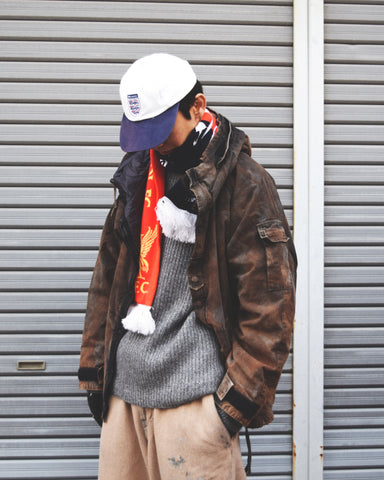 U.S. ARMYのフィールドジャケットをベースに再構築したパーカー。
中綿キルティングを採用し、重すぎず長いシーズン着用可能。
表地はパラフィンコーティングによる軽い撥水性を備えています。
20/リップストップ生地は裂けにくく、マットでしなやかな質感が特徴。
硫化染め後、水を一切使わないサステナブルブリーチを施した特別加工。
独特の風合いと環境配慮を両立した一着です。
A refined take on the U.S. Army field jacket silhouette.
Medium-weight quilted padding offers seasonal versatility without excess bulk.
The paraffin-coated shell provides light water repellency.
Crafted from durable 20/ripstop with a matte, supple texture.
Finished with sulfide dye and a fully water-free sustainable bleachi