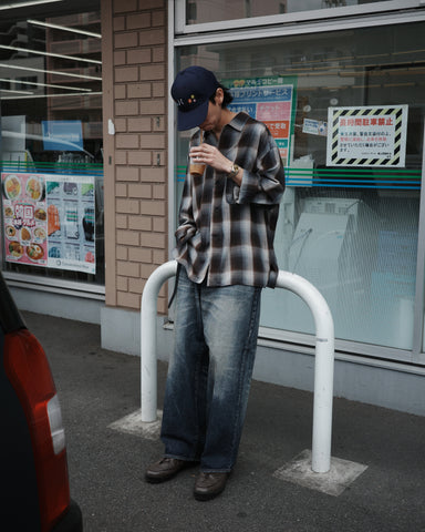 オンブレチェック柄が目を惹くオープンカラーシャツ。生地が持つ自然なドレープ感を活かし、リラックス感のあるゆとりを持たせたシルエットに仕上げました。素材にはタテ・ヨコ共にレーヨン糸を使用したレーヨンチェックを採用。非常に優れた落ち感と、袖を通した瞬間に感じる滑らかで心地よい肌触りが、上質なリラックススタイルを演出します。

An open-collar shirt featuring a classic ombre check pattern. The relaxed silhouette highlights the natural drape and fluid movement of the fabric. Crafted from a high-quality rayon check weave, this BLUE CHECK piece is characterized by its exceptional softness and smooth touch, offering a sophisticated look with an effortlessly comfortable feel.