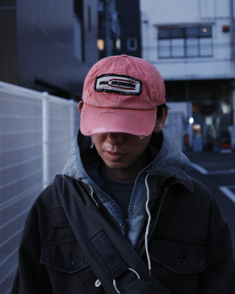 ダメージ加工とステッチ補強で、長年使い込まれた風合いを表現したキャップ。オリジナルワッペンにも同様の加工を施し、全体の統一感を高めました。素材には先染めのピグメントコットンキャンバスを採用。実用性とヴィンテージな佇まいを兼ね備え、スタイリングにこなれたアクセントを添える一着に仕上げています。

A distressed cap featuring reinforced stitching for a rugged, time-worn look. Both the body and the original patch are meticulously aged for a cohesive vintage aesthetic. Crafted from pre-dyed pigment cotton canvas, this RED piece combines durability with a sophisticated, lived-in feel, perfect for adding character to any outfit.