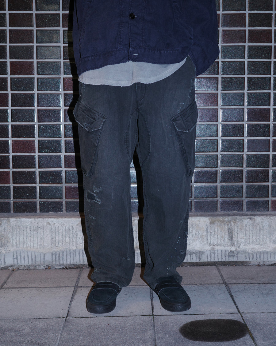 ミリタリートラウザーズを現代的にリファイン。斜めのカーゴポケットが実用的なアクセントを添え、洗練されたテーパードラインが際立ちます。素材には肌馴染みの良い10sヘリンボンを採用。環境に配慮した特殊エイジング・サンフェード加工と随所のリメイクにより、リアリティのある褪色感とヴィンテージな佇まいを表現しました。

Modernized military trousers with a refined tapered fit and slanted cargo pockets. Crafted from soft 10s herringbone, this BLACKA pair features special sun-fading and remake details. It achieves an authentic, time-worn vintage character while utilizing eco-conscious processing to minimize environmental impact.