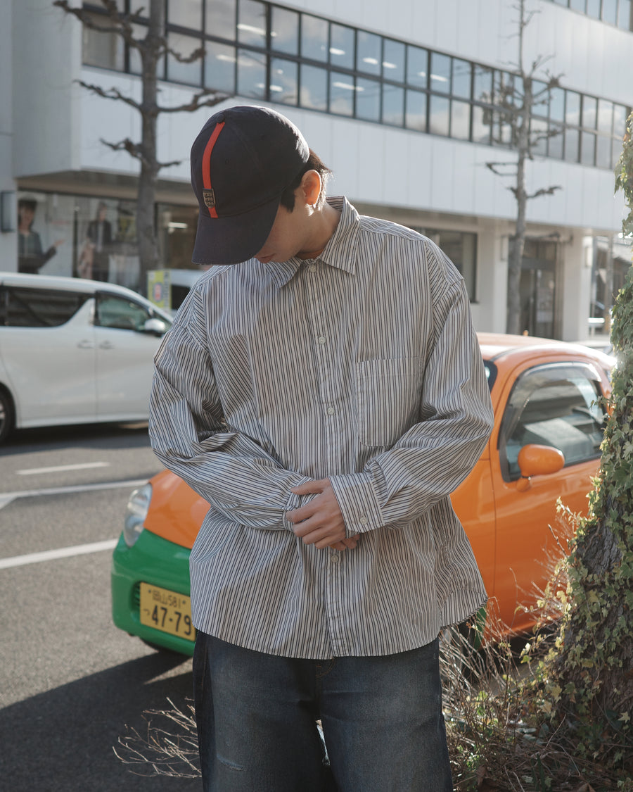 クリーンな高密度ストライプシャツに、スプレーによる顔料吹き付け加工を施し、自然なムラ感を与えた一着。リラックス感のあるシルエットが、上品さとラフさを絶妙なバランスで両立させています。素材には米綿100%の高密度ストライプ生地を採用。綿100%のナチュラルな風合いながら、シワになりにくい実用性も兼ね備えています。

A clean stripe shirt enhanced with a subtle pigment spray process for a natural, textured look. The relaxed silhouette perfectly balances elegance with a casual edge. Crafted from high-density US cotton stripe fabric, this WHITE STRIPE piece offers a crisp feel that is naturally wrinkle-resistant while maintaining the comfort of 100% cotton.