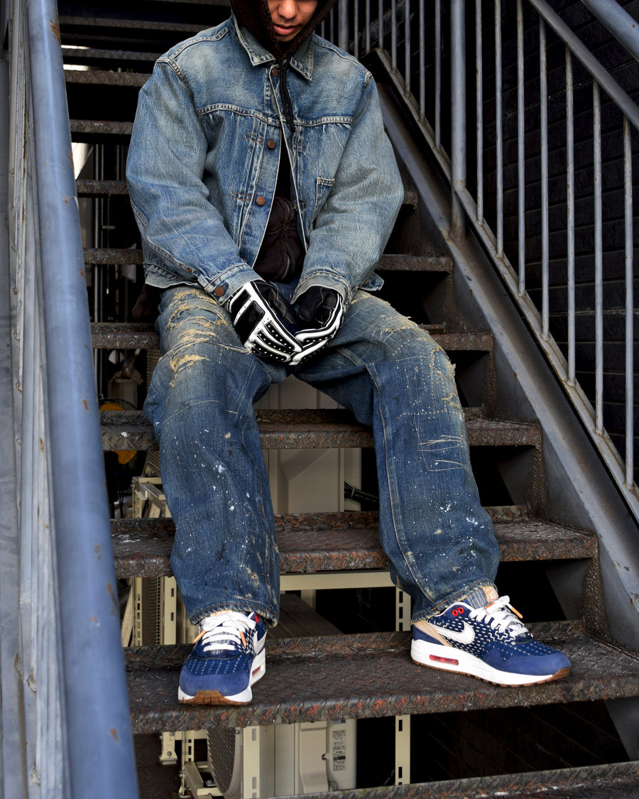 12.5ozデニムを使用したテーパードシルエット。
濃色エイジングとブリーチを組み合わせたハードダメージ加工。
複数の当て布でパッチワークリメイクを施した存在感ある一本です。
A tapered silhouette crafted from 12.5oz denim.
Features heavy damage with dark aging and bleach treatments.
Finished with patchwork-style remake details using multiple fabric patches.