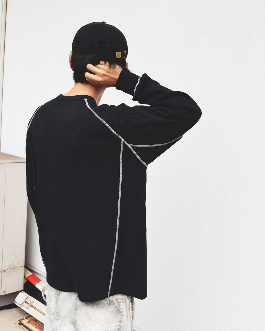 本体とは異なるカラーのステッチを配色としてデザインした中肉の黒色のワッフルロンT