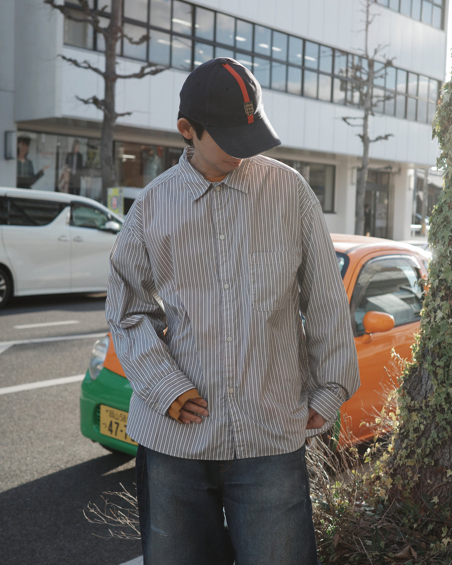 クリーンな高密度ストライプシャツに、スプレーによる顔料吹き付け加工を施し、自然なムラ感を与えた一着。リラックス感のあるシルエットが、上品さとラフさを絶妙なバランスで両立させています。素材には米綿100%の高密度ストライプ生地を採用。綿100%のナチュラルな風合いながら、シワになりにくい実用性も兼ね備えています。

A clean stripe shirt enhanced with a subtle pigment spray process for a natural, textured look. The relaxed silhouette perfectly balances elegance with a casual edge. Crafted from high-density US cotton stripe fabric, this WHITE STRIPE piece offers a crisp feel that is naturally wrinkle-resistant while maintaining the comfort of 100% cotton.