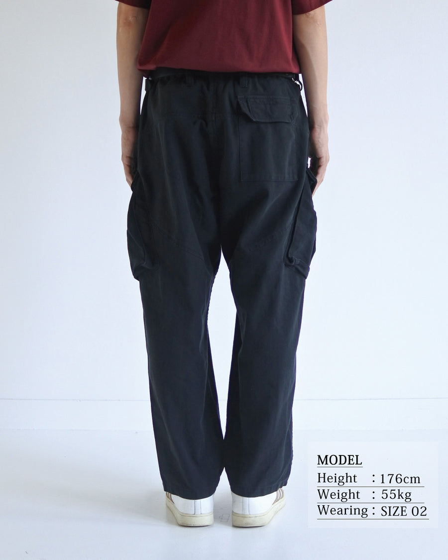ミリタリートラウザーズをベースに、シルエットを現代的にリファイン。印象的な斜めのカーゴポケットが、立体感と実用性を両立させています。裾にかけて緩やかに絞られたテーパードラインにより、無骨ながらも洗練された印象に。素材には肌馴染みの良い10sヘリンボンを採用し、ストーンバイオウォッシュで柔らかな風合いとこなれ感を引き出しました。

Military trousers refined with a modern tapered silhouette. The distinctive slanted cargo pockets offer both practical utility and a structured look. Crafted from soft, classic 10s herringbone, this BLACK pair has been treated with a stone bio-wash, providing a comfortable, worn-in texture and a sophisticated take on rugged style.