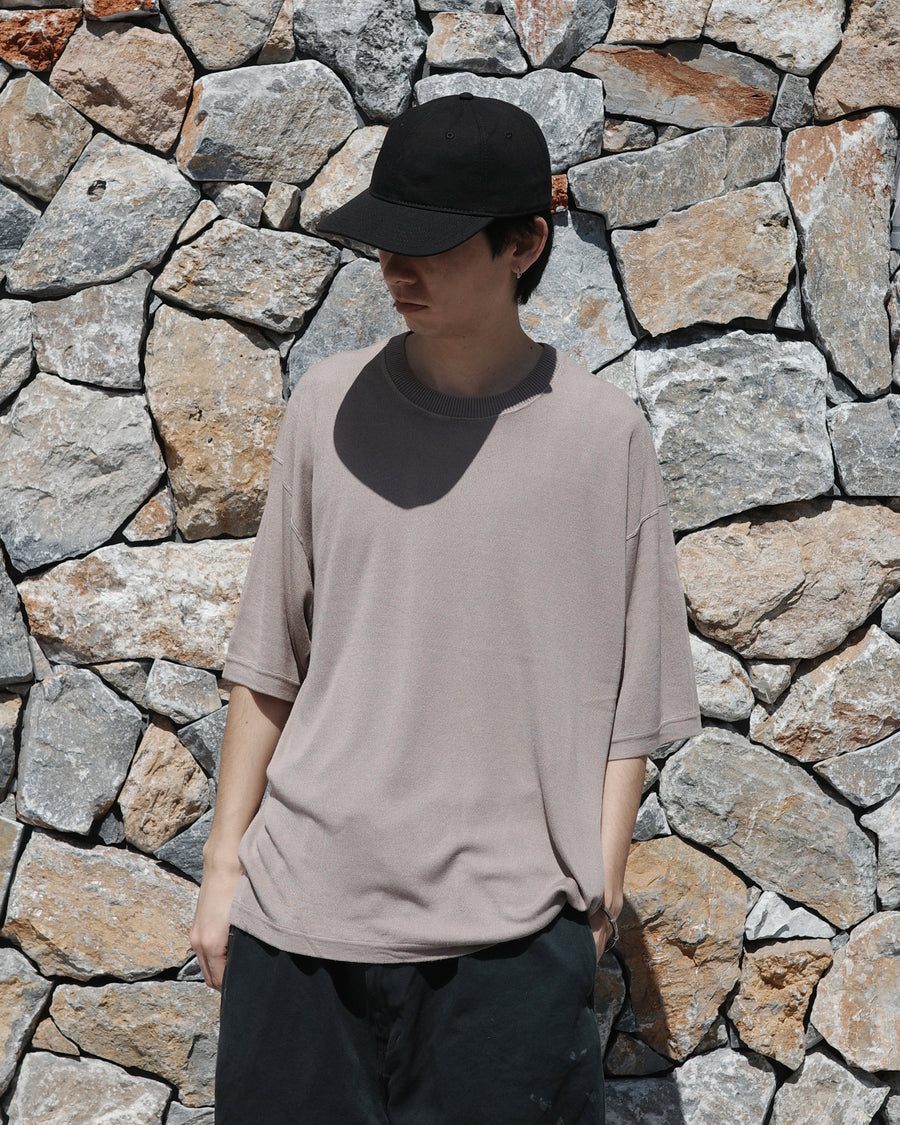 ディテールを極限まで削ぎ落とし、着心地とシルエットを追求したニットTシャツ。気候変化に対応する新たなアプローチとして、軽量で吸水・放湿性に優れた竹（バンブー）素材を採用しました。滑らかでとろみのある肌触りと、袖を通した瞬間に感じる清涼感は格別です。家庭洗濯も可能で、日常に圧倒的な心地よさを提供します。

A minimalist knit T-shirt focused entirely on fit and comfort. Crafted from bamboo yarn, this lightweight, durable material offers exceptional moisture absorption and a refreshing cool-to-the-touch feel. This LIGHT BEIGE piece features a silky, fluid drape that provides overwhelming comfort, perfect for changing climates, and is conveniently home-washable.