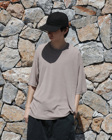 ディテールを極限まで削ぎ落とし、着心地とシルエットを追求したニットTシャツ。気候変化に対応する新たなアプローチとして、軽量で吸水・放湿性に優れた竹（バンブー）素材を採用しました。滑らかでとろみのある肌触りと、袖を通した瞬間に感じる清涼感は格別です。家庭洗濯も可能で、日常に圧倒的な心地よさを提供します。

A minimalist knit T-shirt focused entirely on fit and comfort. Crafted from bamboo yarn, this lightweight, durable material offers exceptional moisture absorption and a refreshing cool-to-the-touch feel. This LIGHT BEIGE piece features a silky, fluid drape that provides overwhelming comfort, perfect for changing climates, and is conveniently home-washable.