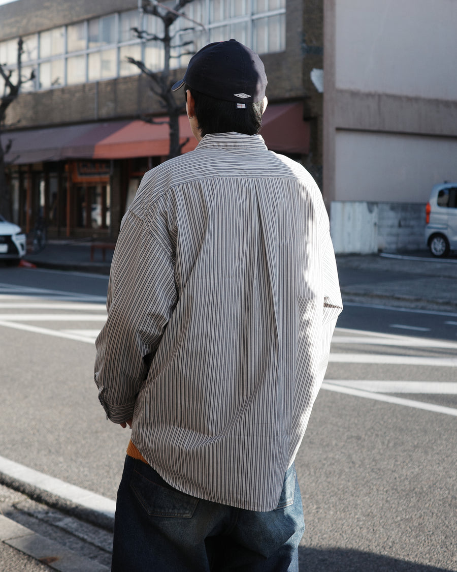 クリーンな高密度ストライプシャツに、スプレーによる顔料吹き付け加工を施し、自然なムラ感を与えた一着。リラックス感のあるシルエットが、上品さとラフさを絶妙なバランスで両立させています。素材には米綿100%の高密度ストライプ生地を採用。綿100%のナチュラルな風合いながら、シワになりにくい実用性も兼ね備えています。

A clean stripe shirt enhanced with a subtle pigment spray process for a natural, textured look. The relaxed silhouette perfectly balances elegance with a casual edge. Crafted from high-density US cotton stripe fabric, this WHITE STRIPE piece offers a crisp feel that is naturally wrinkle-resistant while maintaining the comfort of 100% cotton.